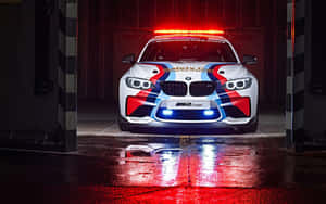 潮濕車庫中帶有紅藍燈光的白色BMW M2 Coupe安全車。 — MacBook Pro 13 壁紙