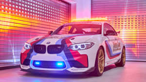 在明亮車庫中的白色BMW賽車，帶有紅藍塗裝。 — 2560x1440 壁紙
