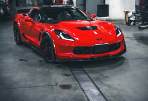 亮紅色Corvette跑車停在有混凝土地板和工具的車庫裡。 — Surface Pro 壁紙