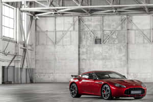 紅色Aston Martin Vantage GTS停放在一個有混凝土牆和鋼樑的工業倉庫中。