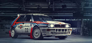 復古 Martini Lancia Delta S4 拉力賽車，停在工業車庫內，帶有贊助商貼紙。 — 超寬螢幕 壁紙