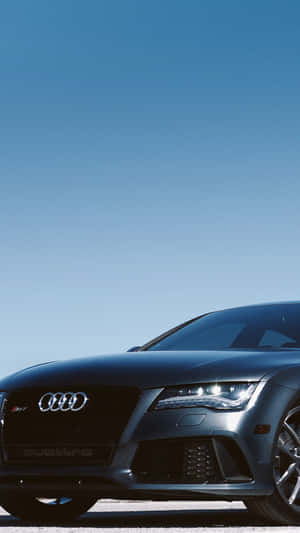 啞光黑色奧迪R8跑車，車頭燈亮起，映襯著清澈的藍天。 — Audi R8 GIF 壁紙