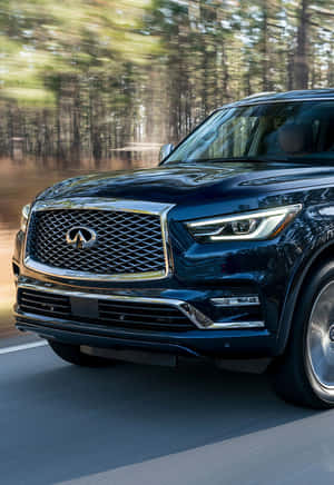 深藍色豪華 SUV 在模糊背景的森林中快速行駛。 — 小米18 Fold 壁紙