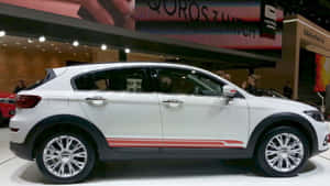 白色Qoros 3掀背SUV，帶有紅色條紋，在車展上展出。 — 酷車 壁紙