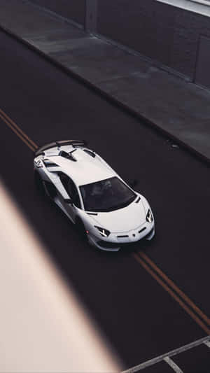 白色林寶堅尼 Aventador SVJ 在街道上高速行駛的俯視圖 — 極簡美學 壁紙