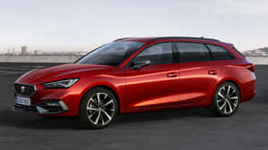 紅色SEAT Leon旅行車停泊在天台，俯瞰城市景觀 — iMac 壁紙
