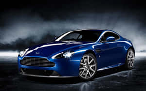 藍色Aston Martin跑車在戲劇性攝影棚燈光及煙霧效果中。 — Steam Deck OLED 壁紙