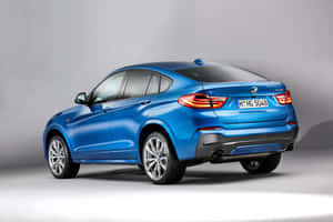 藍色BMW X4轎跑SUV在工作室中，帶有發光的尾燈和鍍鉻輪圈。 — Surface Pro 壁紙