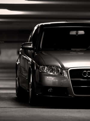時尚的銀色 Audi 房車停放在隧道下，背景有模糊的動態燈光。 — Kindle Paperwhite 壁紙
