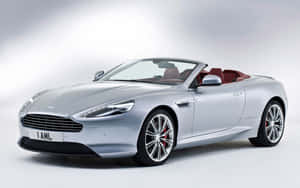 工作室環境中，銀色Aston Martin開篷車配備紅色座椅和鍍鉻輪圈。 — Steam Deck OLED 壁紙