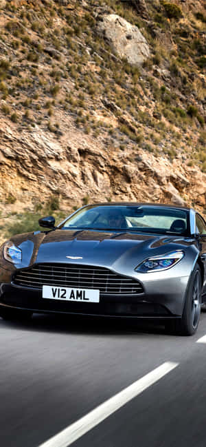 銀色Aston Martin在日落時分的山路上疾馳 — Moto E 壁紙