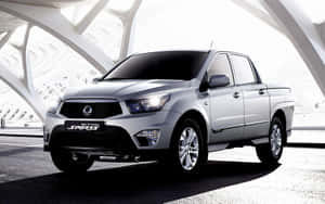 銀色SsangYong Actyon Sports皮卡車在現代白色建築簷篷下。 — MacBook Pro M1 壁紙