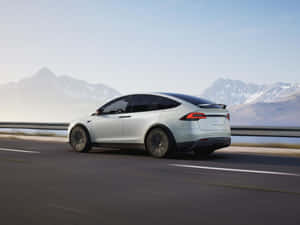 銀色Tesla Model X在高速公路上行駛，背景有雪山 — Tesla GIF 壁紙