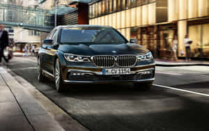 黑色BMW 7系轎車在繁華的城市街道上行駛，行人和建築物模糊。 — Steam Deck OLED 壁紙