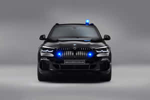 黑色BMW X5 Protection VR6 SUV，在工作室環境中帶有藍色緊急燈光。 — Surface Pro 壁紙