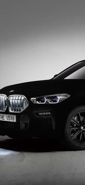 黑色BMW X6 SUV在工作室環境中亮起頭燈。 — Pixel 10 Pro XL 壁紙