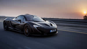 黑色McLaren P1在日落時分於高速公路上疾馳，帶有動態模糊效果。 — 麥拿侖 GIF 壁紙