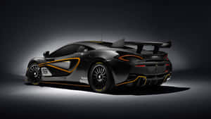 黑色McLaren賽車，帶有橙色飾邊和號碼59，在攝影棚燈光下。 — 麥拿侖 GIF 壁紙