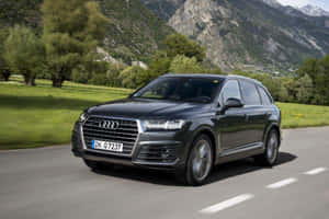 黑色奧迪Q7 SUV在綠樹和岩石山丘的山路上行駛。 — Audi R8 GIF 壁紙