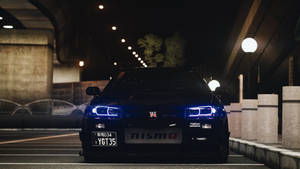 黑色日產GT-R，藍色車頭燈，夜晚停放在城市天橋下。 — 汽車 壁紙