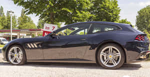 黑色法拉利 GTC4Lusso 停在加油站旁，有綠樹 — 4K 法拉利 壁紙