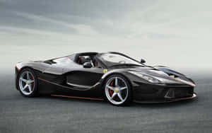 黑色法拉利 LaFerrari Aperta 帶紅色點綴，停在灰色瀝青路面，天空多雲 — MacBook Pro M1 壁紙