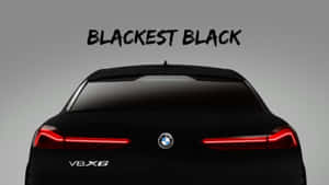 黑色BMW V8X6汽車後視圖，帶紅色尾燈和'BLACKEST BLACK'文字。 — 暗色 壁紙