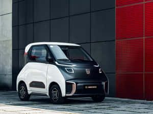 緊湊型電動車停在紅色和灰色牆前。 — 酷車 壁紙