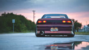 栗色跑車在黃昏時倒影在水坑中，尾燈閃閃發光。 — Jdm 美學 壁紙