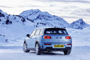 淺藍色Mini Cooper Clubman停泊在雪地山景中。 — Surface Pro 壁紙