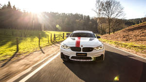 白色Manhart BMW M4在日落時分的鄉間道路上疾馳。 — 汽車 壁紙