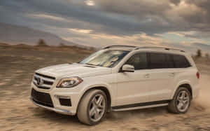 白色 Mercedes GLS SUV 在日落時分行駛於沙漠地形。 — Steam Deck 壁紙