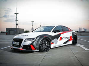 白色、紅色和黑色的Audi RS7 MD700跑車停在日落時的混凝土上。 — 奧迪 GIF 壁紙