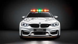 白色BMW M4 GTS賽車，配備安全燈和贊助商貼紙，在工作室中。 — Studio Display 壁紙