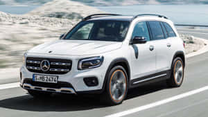 白色Mercedes-Benz GLB SUV在海岸公路上行駛，帶有動態模糊效果。 — 酷車 壁紙