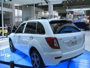 車展上藍色展台上的白色力帆SUV。 — 機車 壁紙