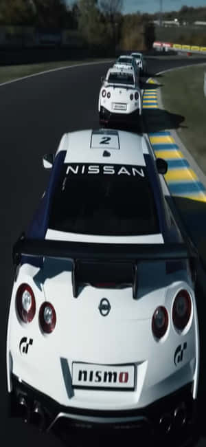 白色日產GT-R尼桑賽車車號二在日落時分的賽道上。 — POCO X8 壁紙
