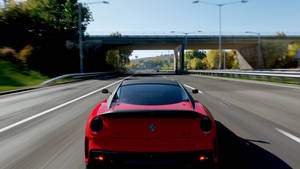 紅色法拉利在天橋下的高速公路上行駛，路邊有秋樹 — 4K 法拉利 壁紙