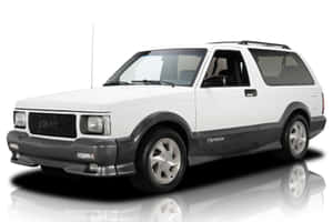 白色GMC Typhoon SUV，帶有黑色飾邊和銀色輪圈，在反射的攝影棚地板上。 — 低飽和度 壁紙