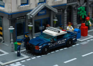 LEGO警車停泊在警察局外，配有警員和街道元素。 — 夜景城市 壁紙