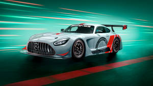 銀色 Mercedes-AMG GT3 賽車在賽道上以青綠色和紅色動態模糊效果疾馳。 — 平治 C300 壁紙