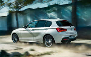 銀色BMW掀背車在塵土飛揚的道路上高速行駛，帶有動態模糊效果。 — 1280x800 壁紙