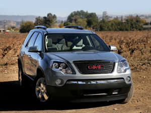 銀色GMC Acadia SUV停泊在葡萄園附近的泥路上。 — 美景 壁紙