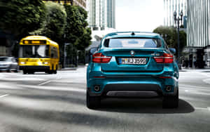 青綠色的BMW X6 SUV在繁忙的城市街道上行駛，一輛黃色巴士經過。 — Steam Deck OLED 壁紙