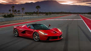 日落時分，紅色法拉利 LaFerrari 在賽道上，背景有山脈和棕櫚樹。 — 4K 法拉利 壁紙