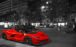 一輛紅色的法拉利LaFerrari在夜晚停泊在城市的街道上。 — 2880x1800 壁紙