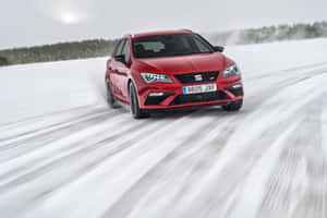 紅色汽車在雪地上飄移，背景是森林 — Surface Laptop 壁紙