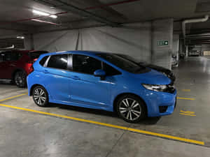 藍色小型車停放在設有黃線的地下停車場。 — 本田 壁紙