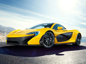 黃色McLaren P1超級跑車停放在海岸公路上，背景有山脈和城市。 — 美學黃色 壁紙
