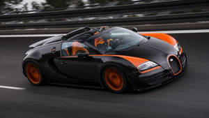 黑色和橙色的Bugatti Veyron在賽道上高速行駛。 — 汽車 壁紙
